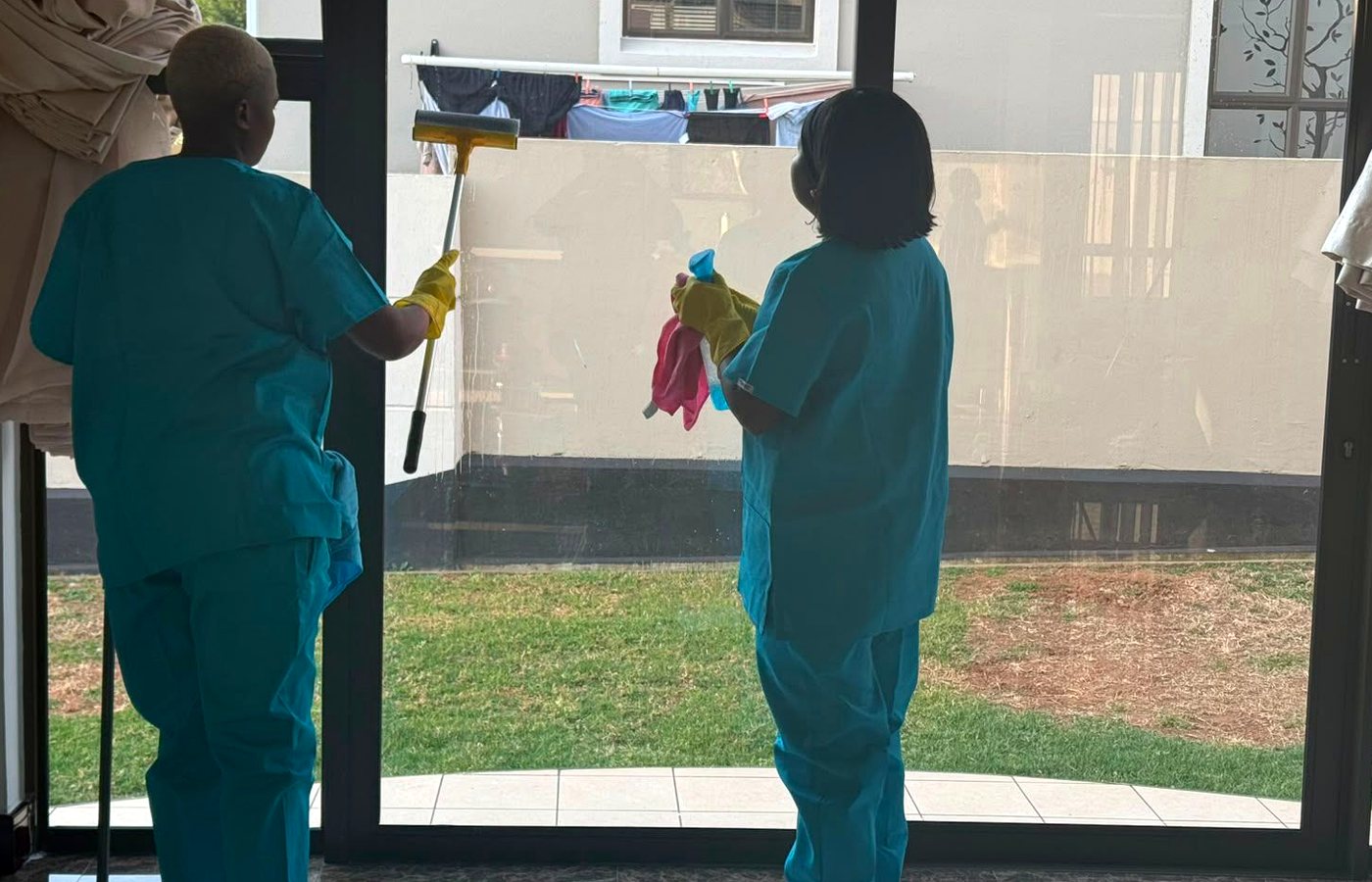 PrimeCare cleaners working together on a glass and floor clean